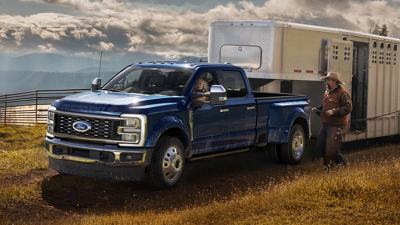 Ford Super Duty F-350 2026 bleu marine remorquant une lourde remorque de travail chargée, illustrant la puissance de remorquage maximale de la gamme Super Duty