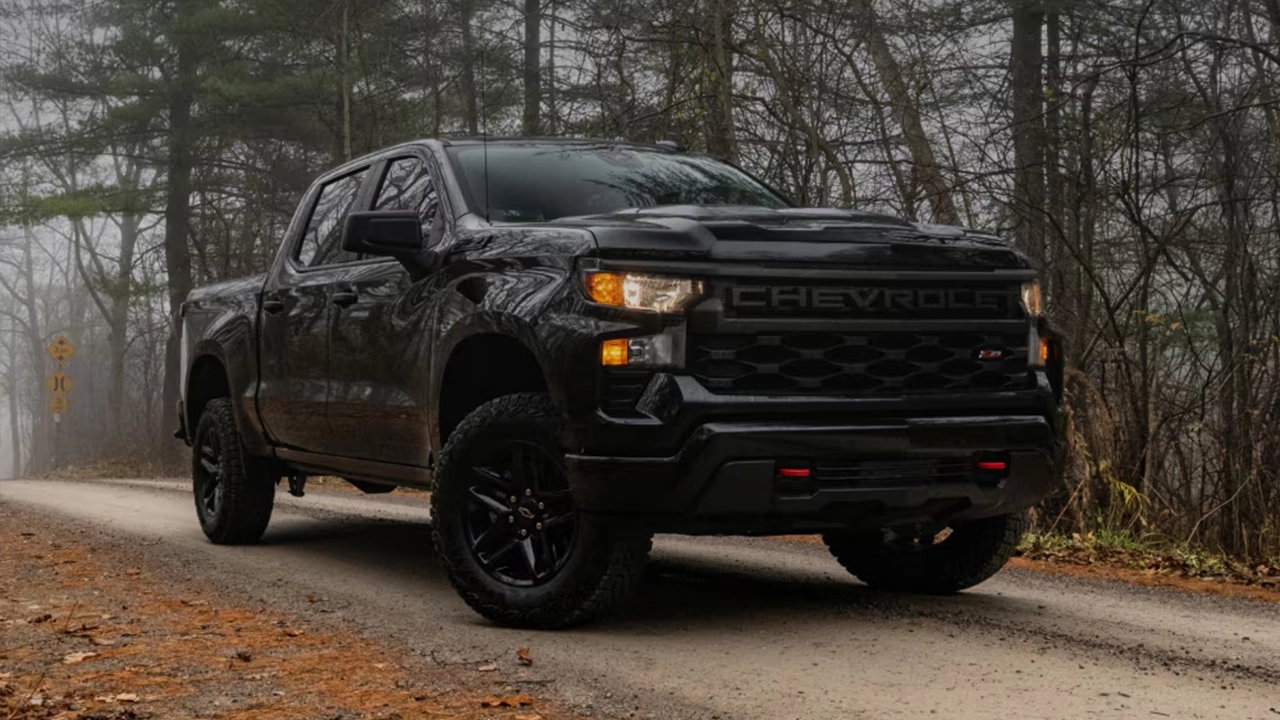 Chevrolet Silverado 2026 noir sur route brumeuse en forêt.