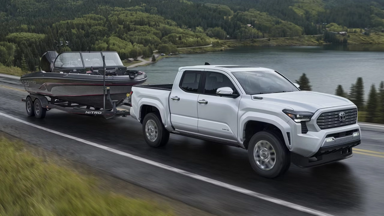 Toyota Tacoma blanc 2026remorquant un bateau près d'un lac.