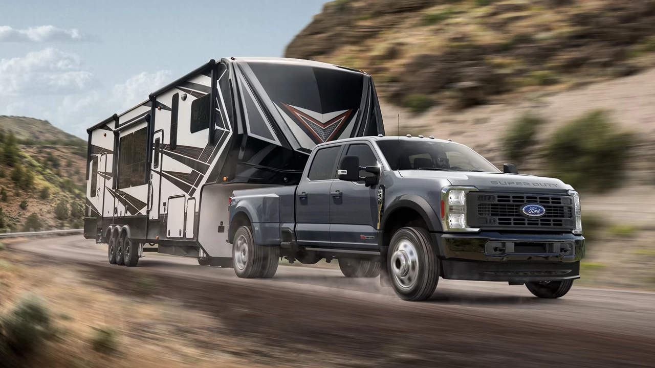 Vue avant latérale du Ford F-450 Super Duty 2026 tirant une roulotte sur route en pleine puissance