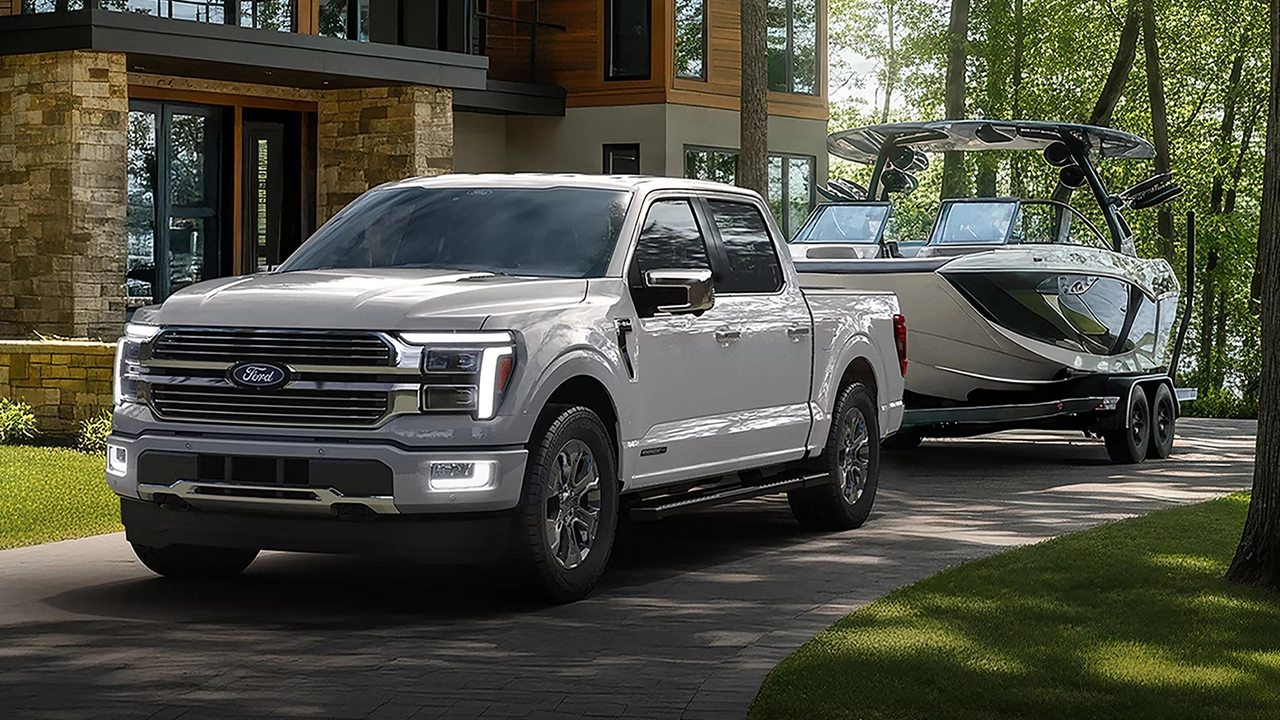 Ford F-150 PowerBoost tirant un bateau et quittant la maison