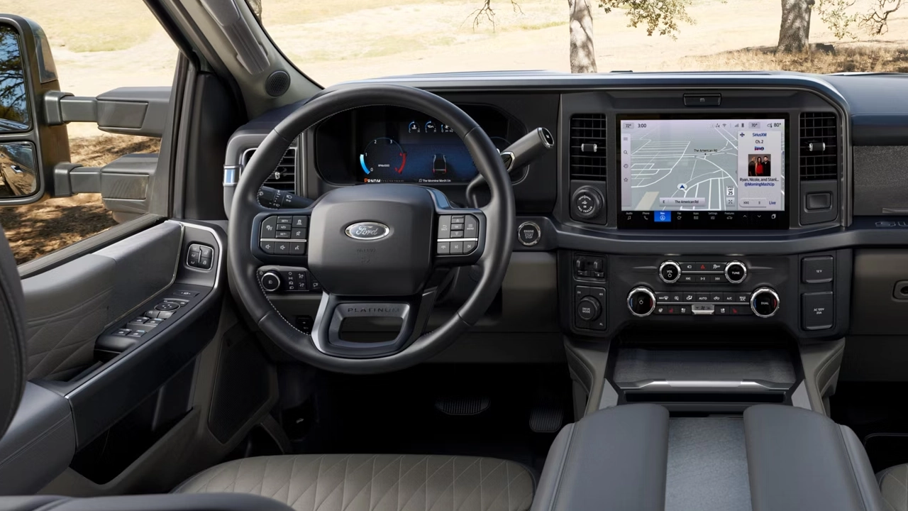 Tableau de bord du Ford F-250 avec grand écran tactile de navigation, instrumentation numérique et finitions bicolores gris et beige.